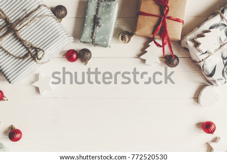 wrapped present boxes with ornaments on white wooden background top view, space for text. christmas flat lay frame. seasonal greetings card. happy holidays. merry christmas concept