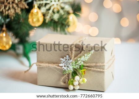 A Christmas tree decorated snowflakes and a garland with gift box on the background of a bokeh and white boards. Merry Christmas, ideas for postcards for winter holidays