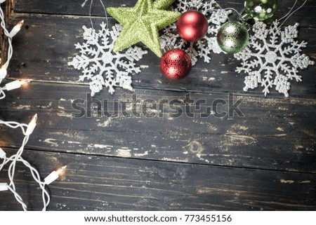 Christmas holiday ornaments and lights on a dark vintage wood background.