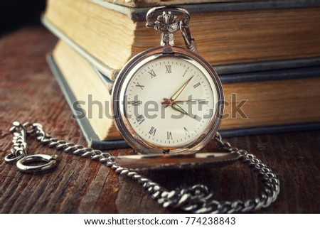 vintage watch on a chain on a background of old books