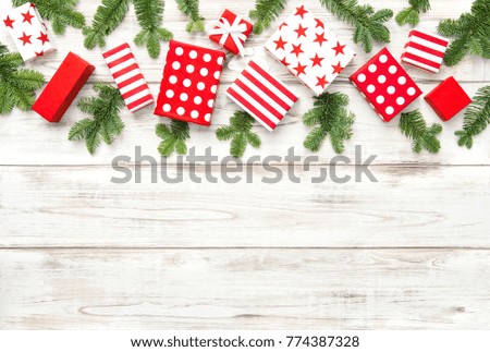 Red Christmas decoration, gifts and pine tree branches on bright wooden background. 