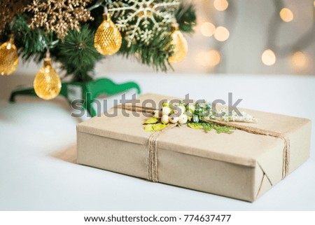 A Christmas tree decorated snowflakes and a garland with gift box on the background of a bokeh and white boards. Merry Christmas, ideas for postcards for winter holidays