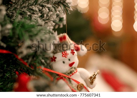 
a snowman hanging on a Christmas tree against the backdrop of a New Year's garland