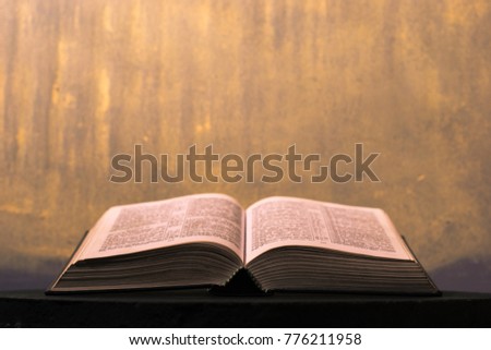 Bible on a dark table. Beautiful gold background.Religion concept.