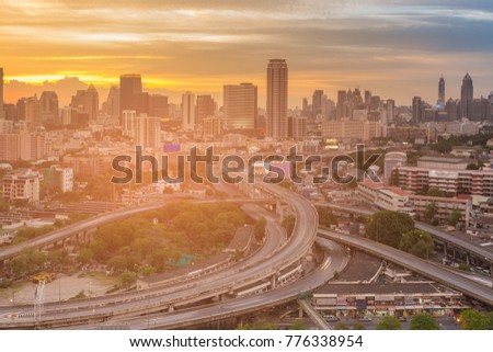 Business office building and interchanged overpass road with sunset tone, cityscape background