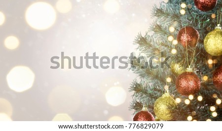 Closeup of Christmas tree with colorful lamp decoration over blurred light background