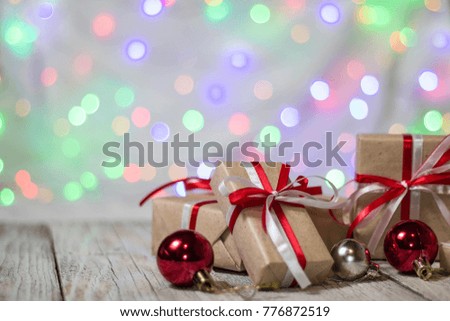 Christmas gift box with balls against bokeh background. Holiday greeting card.