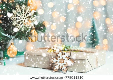 A Christmas tree decorated snowflakes and a garland with gift box on the background of a bokeh and white boards. Merry Christmas, ideas for postcards for winter holidays and snow