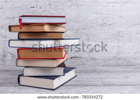 On a wooden background, a stack of books. The concept of education. With a place for an inscription.