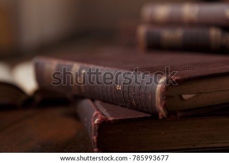 Old books on rustic wooden table. Stack of books. Background blurred. Scenery rustic, brown and warm.