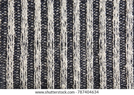 Wool pullover with gray and black stripes, texture background.