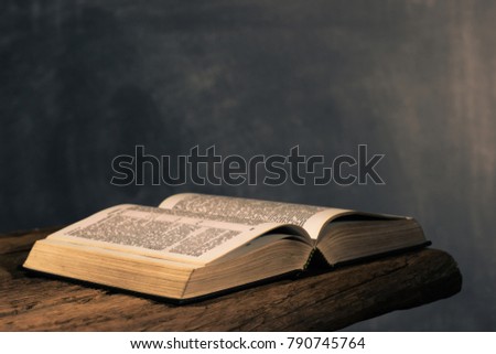 Holy Bible on a old oak wooden table. Beautiful dark background.Religion concept