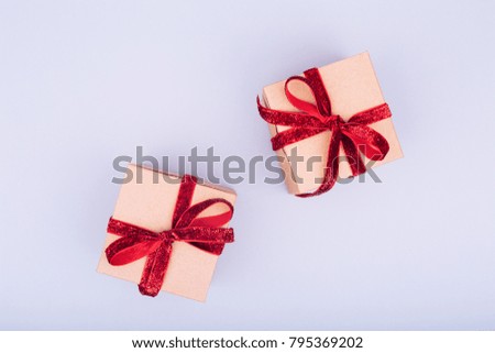 Craft box with red ribbon bow. Valentine day concept. Trendy minimalistic flat lay design background. Horizontal