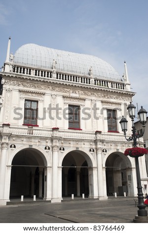 Brescia (Lombardy, Italy), Loggia Palace, historic building of Renaissance era with street light and red flowers