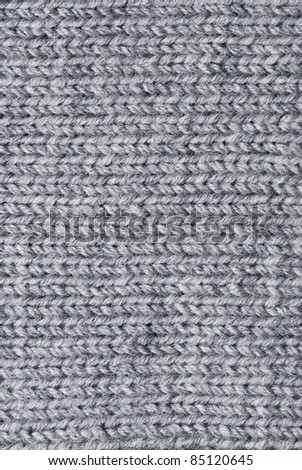 Knit woolen texture. Fabric gray background