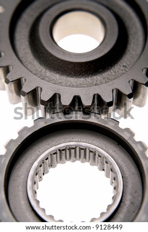 Closeup of two gears over white