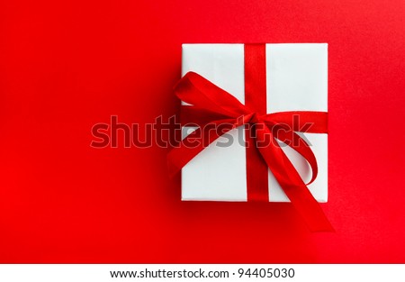 Small gift with red bow on red background. Space for your text.